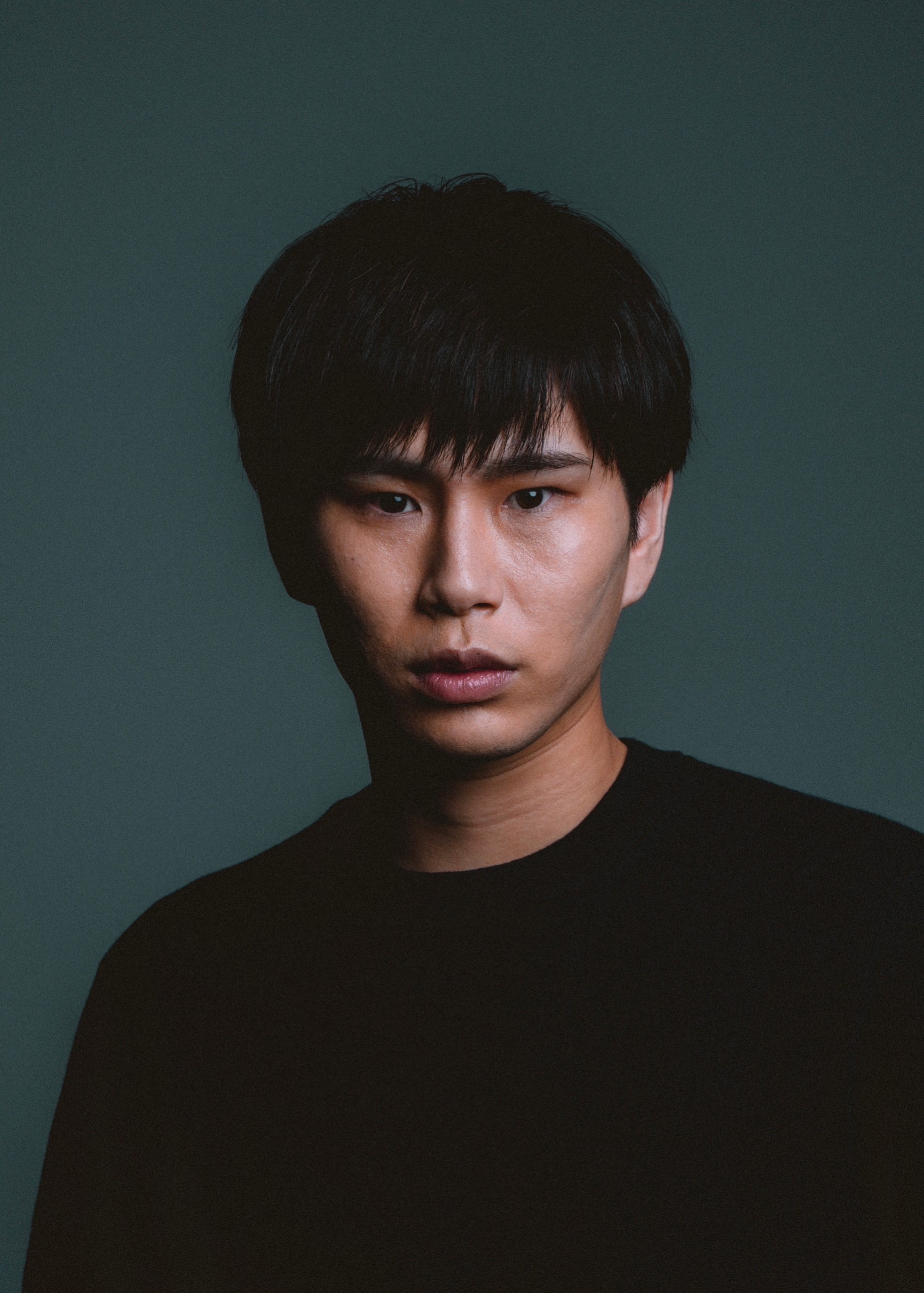 黒い衣装を着て正面を向く政野郁弥